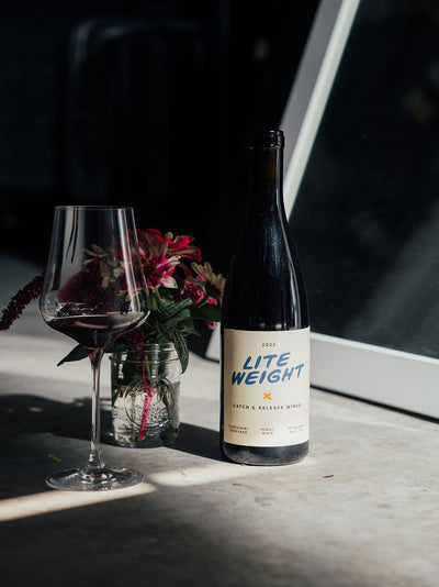 Catch & Release Wines 2022 Lite Weight on concrete with flowers and poured glass