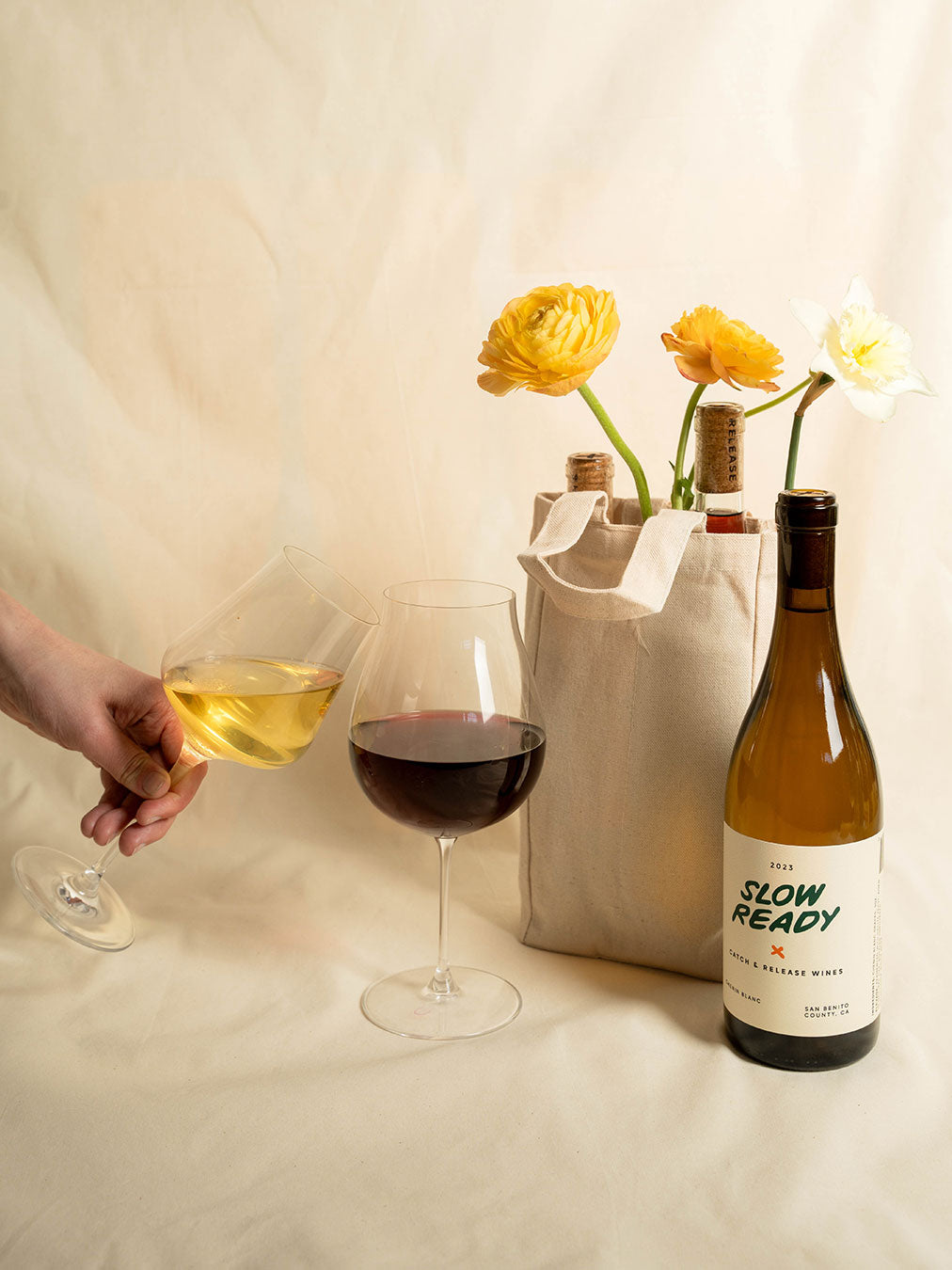 Catch & Release Natural Wine Slow Ready Chenin Blanc bottle, gift tote and glasses of wine next to it